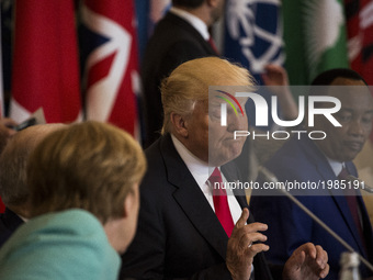 U.S. President Donald Trump (R) talks to German Chancellor Angela Merkel (L) during the G7 Summit expanded session in Taormina, Sicily, on M...