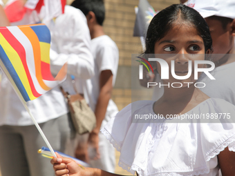Sri Lankan girl holds a Buddhist flag during the festival of Vesak in Mississauga, Ontario, Canada, on 28 May 2017. Vesak (Wesak) commonly k...
