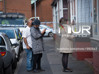 Beth Abbit (in the biege coat), journalist for the Manchester Evening News, interveiws a resident on the street for a Manchester Evening New...