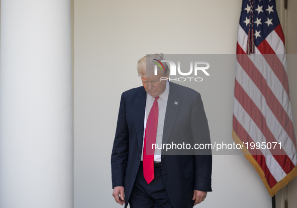President Trump walks out to make his statement that the United States is withdrawing from the Paris Climate Accord, in the Rose Garden of t...
