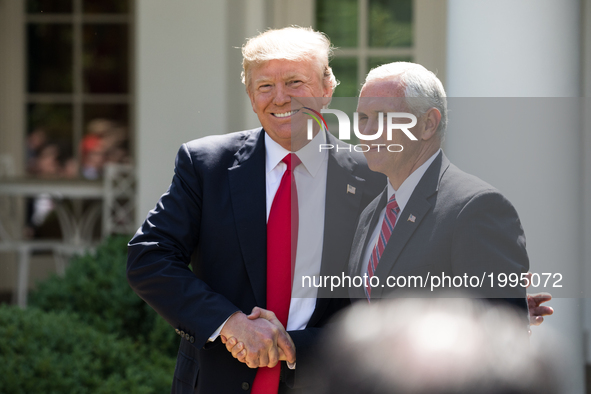 President Donald Trump greets VP Mike Pence before making his statement that the United States is withdrawing from the Paris Climate Accord,...