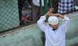 A Nepalese Muslim kid plays as puts cap on his head before offering ritual prayer of Ramad...