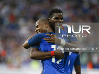 France's defender Djbril Sidibe (L) is embraced by teammate midfielder Paul Pogbaafter scoring during the international friendly football ma...