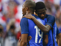 France's defender Djbril Sidibe (L) is embraced by teammate forward Ousmane Dembele after scoring during the international friendly football...