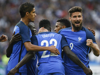France's defender Samuel Umtiti (C/#22) is embraced by teammates after scoring during the international friendly football match between Fran...