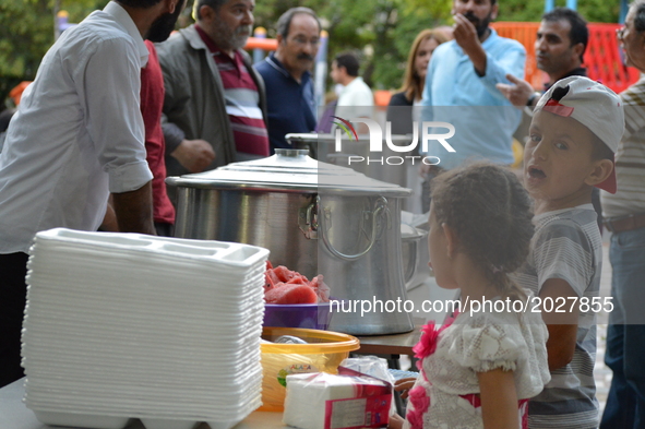 Children wait in line to get their food platters at the pro-Kurdish opposition Peoples' Democratic Party's (HDP) iftar dinner meeting in ord...