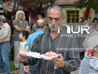 A man carries his food platter at the pro-Kurdish opposition Peoples' Democratic Party's (HDP) iftar dinner meeting in order to protest agai...