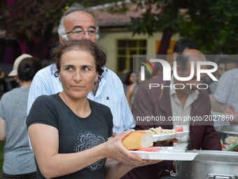 People carry their food platters at the pro-Kurdish opposition Peoples' Democratic Party's (HDP) iftar dinner meeting in order to protest ag...