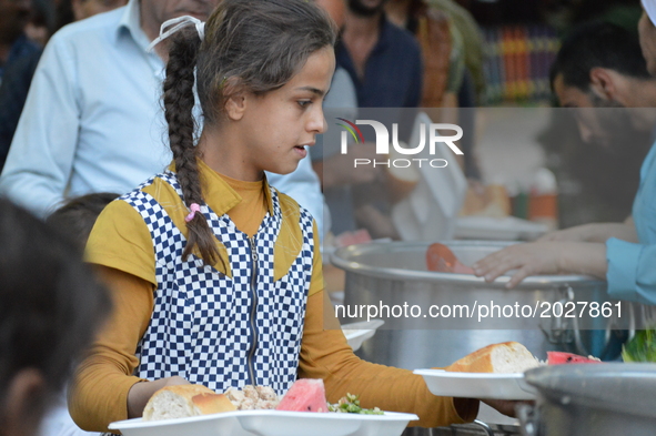 A girl carries two food platters at the pro-Kurdish opposition Peoples' Democratic Party's (HDP) iftar dinner meeting in order to protest ag...