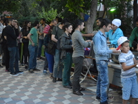 People wait in line to get their food platters at the pro-Kurdish opposition Peoples' Democratic Party's (HDP) iftar dinner meeting in order...
