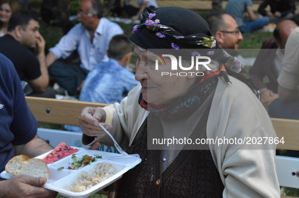 An elderly woman breaks her fast at the pro-Kurdish opposition Peoples' Democratic Party's (HDP) iftar dinner meeting in order to protest ag...
