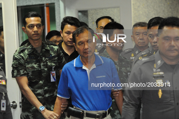 Watana Pumret (in blue shirt), suspected of a bomb attack on the military Phramongkutklao Hospital, is escorted by Thai soldiers and policem...