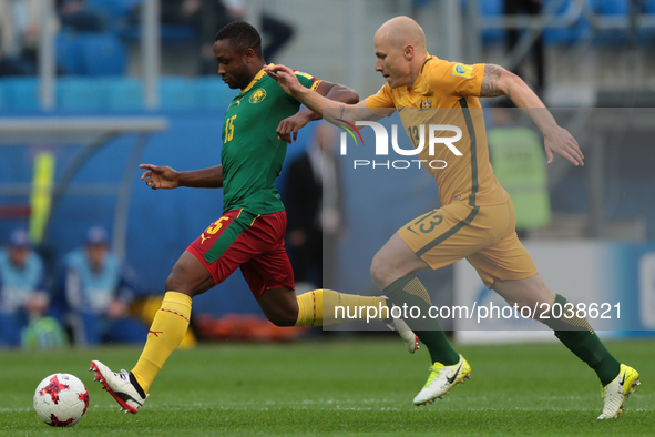 Sebastien Siani (L) of the Cameroon national football team and Aaron Mooy of the Australia national football team vie for the ball during th...