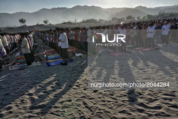 Indonesian Muslims gather to perform Eid Al-Fitr prayer on sand dunes at Parangkusumo beach, Yogyakarta, Indonesia on June 25, 2017. Muslims...