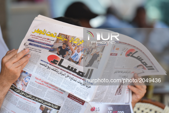 A person reads 'Al Massae' - an Arabic-speaking Moroccan daily, reporting on yesterday's violent demonstrations and riots that took place in...