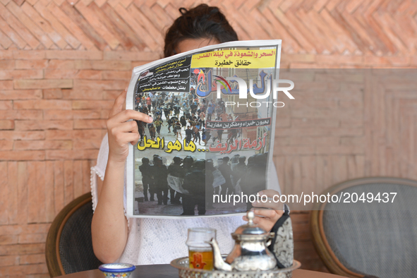 A person reads 'Al Michaal' - an Arabic-speaking Moroccan daily, reporting on yesterday's violent demonstrations and riots that took place i...