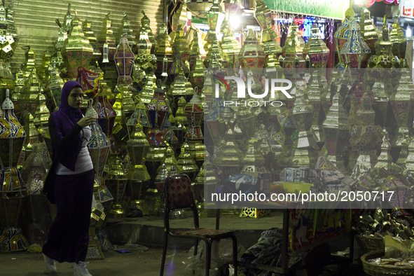 A muslim woman stands in front of a Ramadan lap street shop in Cairo on June 12, 2017 