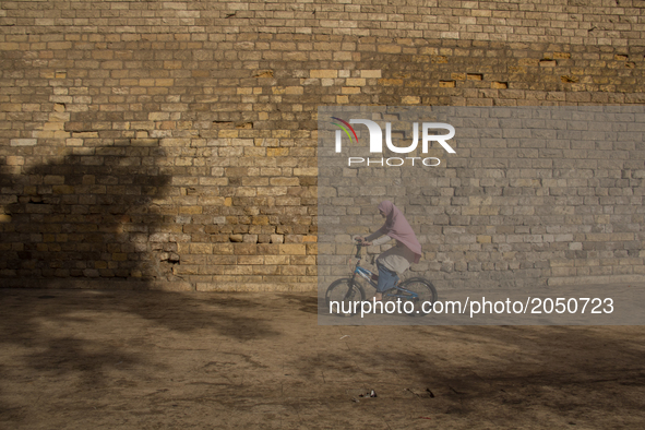 A muslim woman is riding a bicycle outside Al-Anwar mosque in Cairo on June 13, 2017 