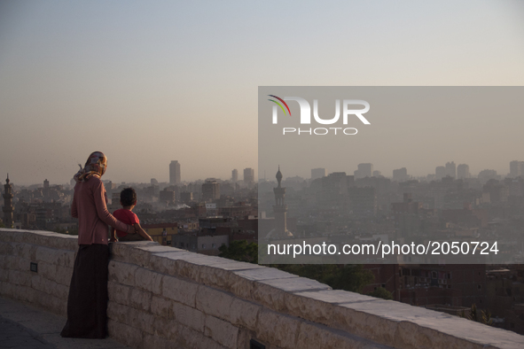 A woman and her son are watching the sunset from Al-Azhar park in Cairo on June 9, 2017 