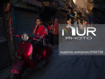 A kid in a motocycle is posing for a picture in Old Cairo on June 15, 2017 (