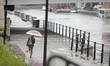 A woman is seen walking along the Brda river on a stormy day in Bydgoszcz, Poland on 30 Ju...