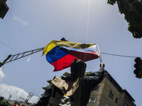 A demonstrator holds a venezuelan flag during a street blocking. Demonstrators use mask to cover their faces from the security forces. Carac...