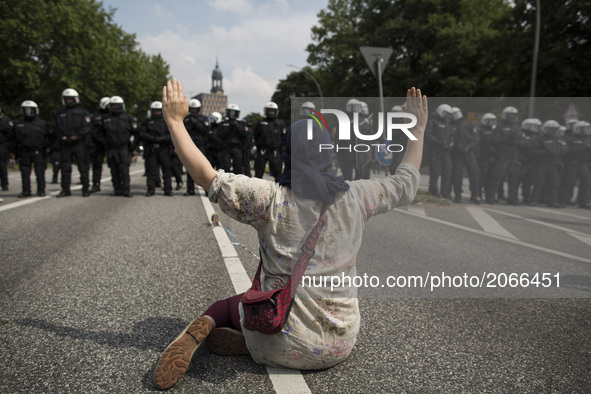 Germany, Hamburg: A woman sits in front of german riot police during protests  during the G20 summit in Hamburg, Germany, on July 7, 2017. 