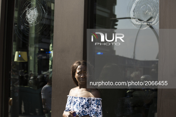 Germany, Hamburg:a woman stands next to a damaged window  during the G20 summit in Hamburg, Germany, on July 7, 2017. 