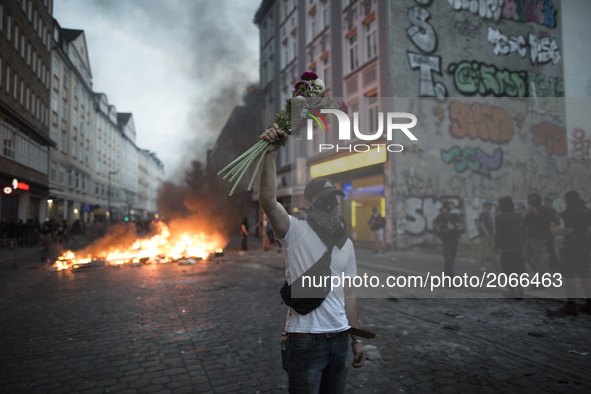 Germany, Hamburg: a demonstrator holds flowers during protests  during the G20 summit in Hamburg, Germany, on July 7, 2017. 