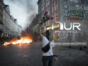 Germany, Hamburg: a demonstrator holds flowers during protests  during the G20 summit in Hamburg, Germany, on July 7, 2017. (