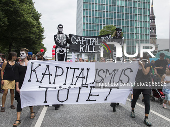 People holding a banner reading 'capitalism kills' attend a protest march against the G20 Summit with the topic 'Solidarity without borders...