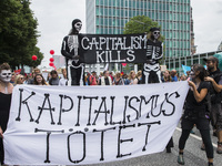 People holding a banner reading 'capitalism kills' attend a protest march against the G20 Summit with the topic 'Solidarity without borders...