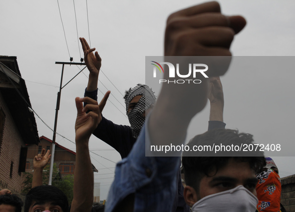 Kashmiri Masked protesters chant pro-freedom slogans during the funeral  of a local  pro-Independence fighter Aqib Ahmad in Srinagar on july...