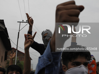 Kashmiri Masked protesters chant pro-freedom slogans during the funeral  of a local  pro-Independence fighter Aqib Ahmad in Srinagar on july...