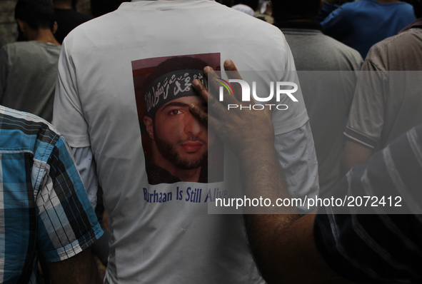A kashmiri protester wearing a shirt with a poster of Burhan wani Top rebel leader killed last year  takes part in the funeral procession of...