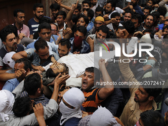 kashmiri people chant pro-freedom slogans  as they carry the body of  local pro-independence fighter  Sajad Ahmed Gilkar during his  funeral...