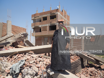 An Egyptian woman standing in front of a destroyed house in al-Warraq Island, Giza, Egypt, 18 July 2017. Clashes broke at the island of al-W...