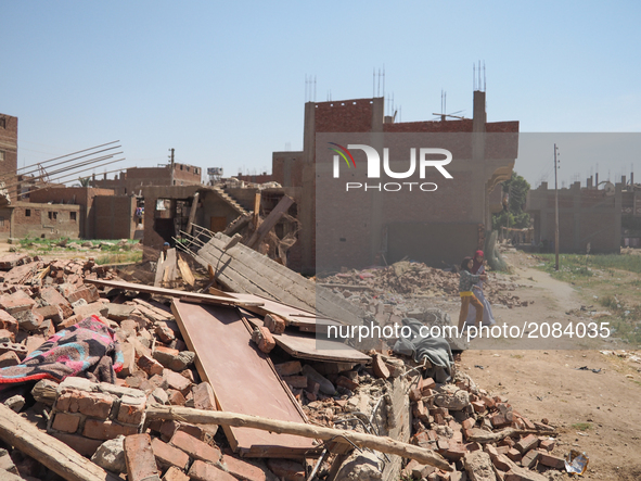 An Egyptian woman and her daughter walk near a destroyed house in al-Warraq Island, Giza, Egypt, 18 July 2017. Clashes broke at the island o...