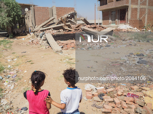 Two Egyptian children, family standing in front of a destroyed house in al-Warraq Island, Giza, Egypt, 18 July 2017. Clashes broke at the is...