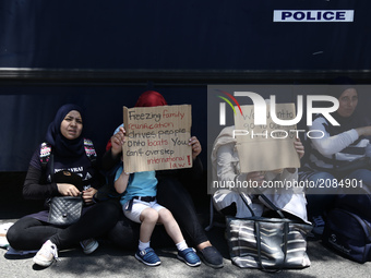 Mothers with their children hold placards in front of a police bus close to the German embassy in Athens on Wednesday 19 July 2017. Refugees...
