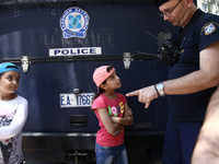 A police officer talks to a refugee boy, during a protest rally, close to the German embassy in Athens on Wednesday 19 July 2017. Refugees,...