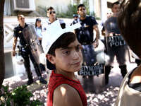 Refugee boys and riot police officers, during a protest rally, close to the German embassy in Athens on Wednesday 19 July 2017. Refugees, ma...