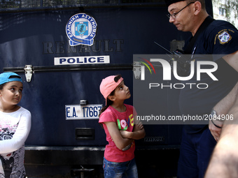 A police officer talks to a refugee boy, during a protest rally, close to the German embassy in Athens on Wednesday 19 July 2017. Refugees,...