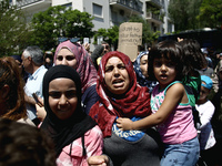 Refugee mothers with their children shout slogans outside the German embassy in Athens on Wednesday 19 July 2017. The refugees, mainly Syria...