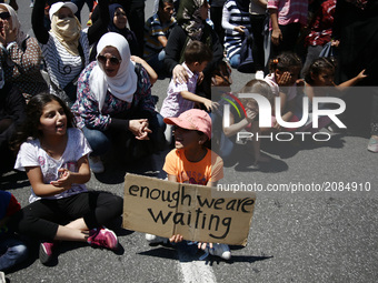 Mothers with their children block the street, during a protest close to the German embassy in Athens on Wednesday 19 July 2017. The refugees...