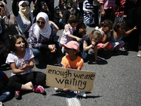 Mothers with their children block the street, during a protest close to the German embassy in Athens on Wednesday 19 July 2017. The refugees...