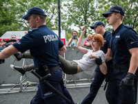 Policemen carry a protester away from a demonstration in front of the Sejm (Lower House of Polish Parliament) building in Warsaw, Poland on...