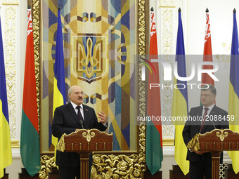 Belarussian President Alexander Lukashenko (L) and Ukrainian President Petro Poroshenko (R) speaks with journalists during a press-conferenc...