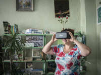 Yana Synytsia wears virtual reality glasses in a village club in Kryva Luka in Donetsk region, ATO zone, Ukraine on July 24, 2017. Yana is a...