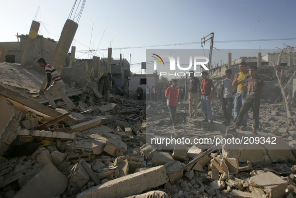 Palestinian men looking at the house after was hit by an Israeli military strike in Rafah in the southern Gaza Strip on August 10, 2014. Isr...